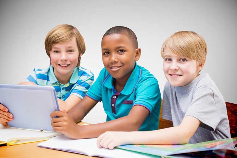 Three students collaborating around a laptop